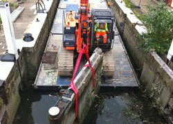 Old lock mitre gates being lifted out at Thames Weir Lock, Brentford, London on the Grand Union Canal.
